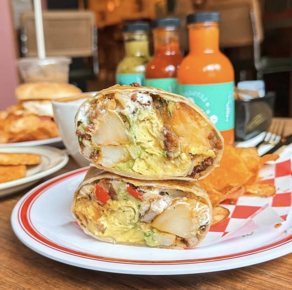 Close up photo of breakfast burrito cut in half 
